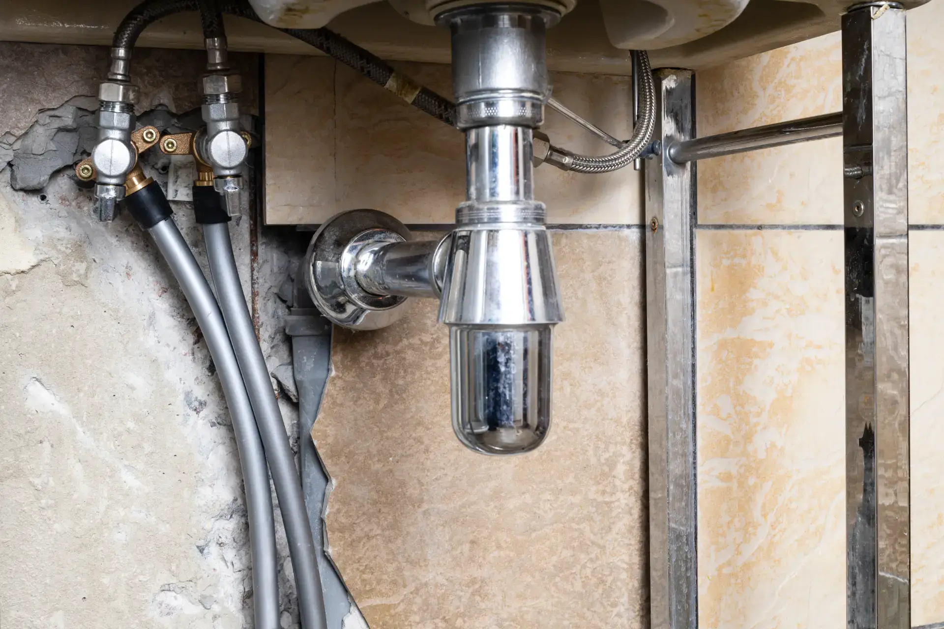 VVS-ventilationsrør under vasken i et køkken.